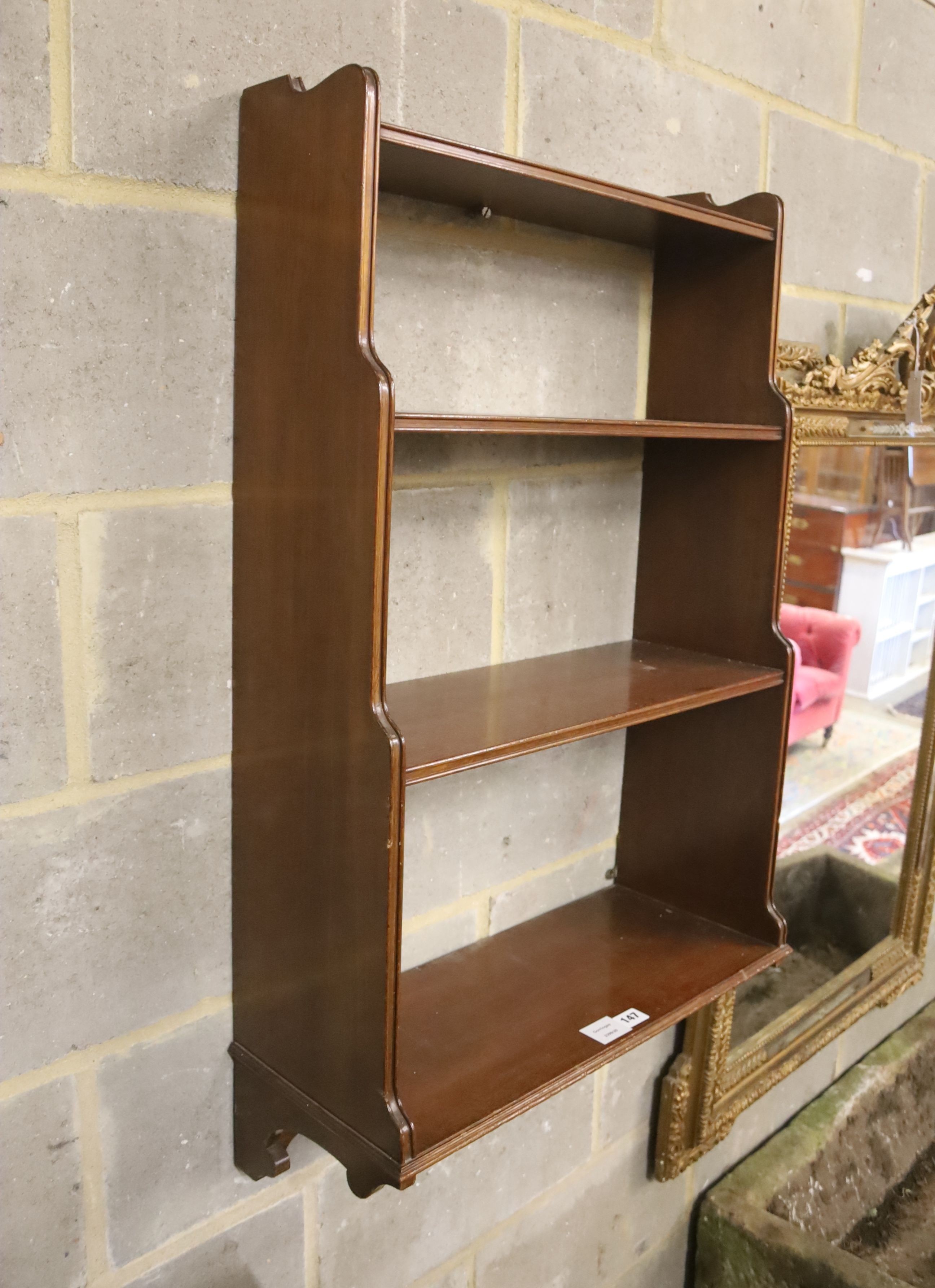 A mahogany three shelf wall bracket, width 57cm, depth 23cm, height 94cm